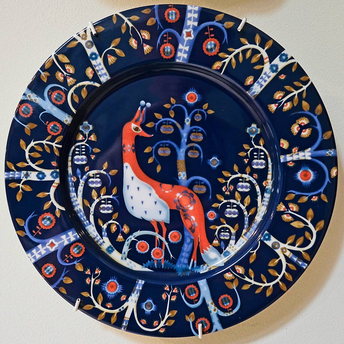 A dark blue plate with an orange bird