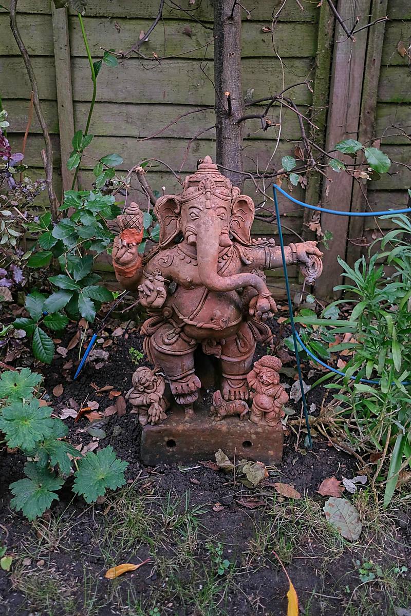 A clay Ganesha among plants in the garden